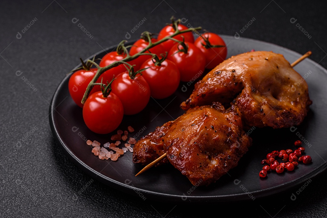 Kebab de frango suculento com sal, especiarias e ervas em um fundo escuro de concreto