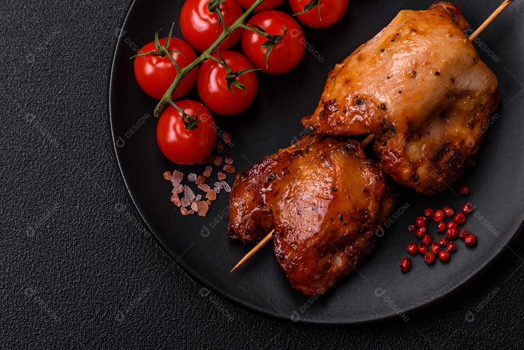Kebab de frango suculento com sal, especiarias e ervas em um fundo escuro de concreto