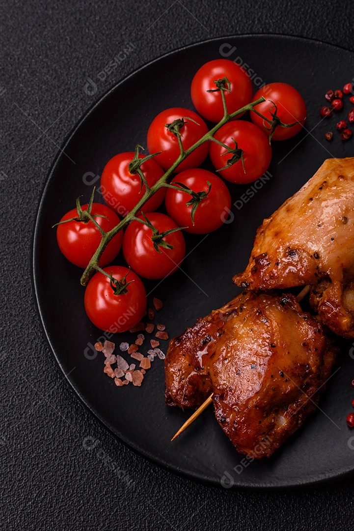 Kebab de frango suculento com sal, especiarias e ervas em um fundo escuro de concreto