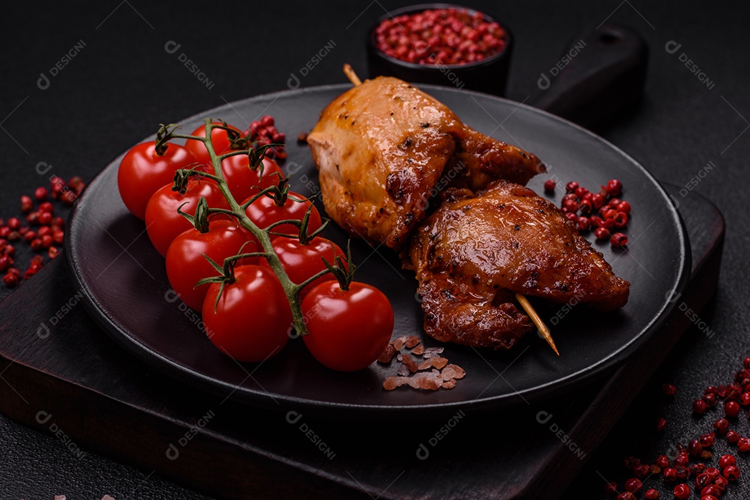 Kebab de frango suculento com sal, especiarias e ervas em um fundo escuro de concreto