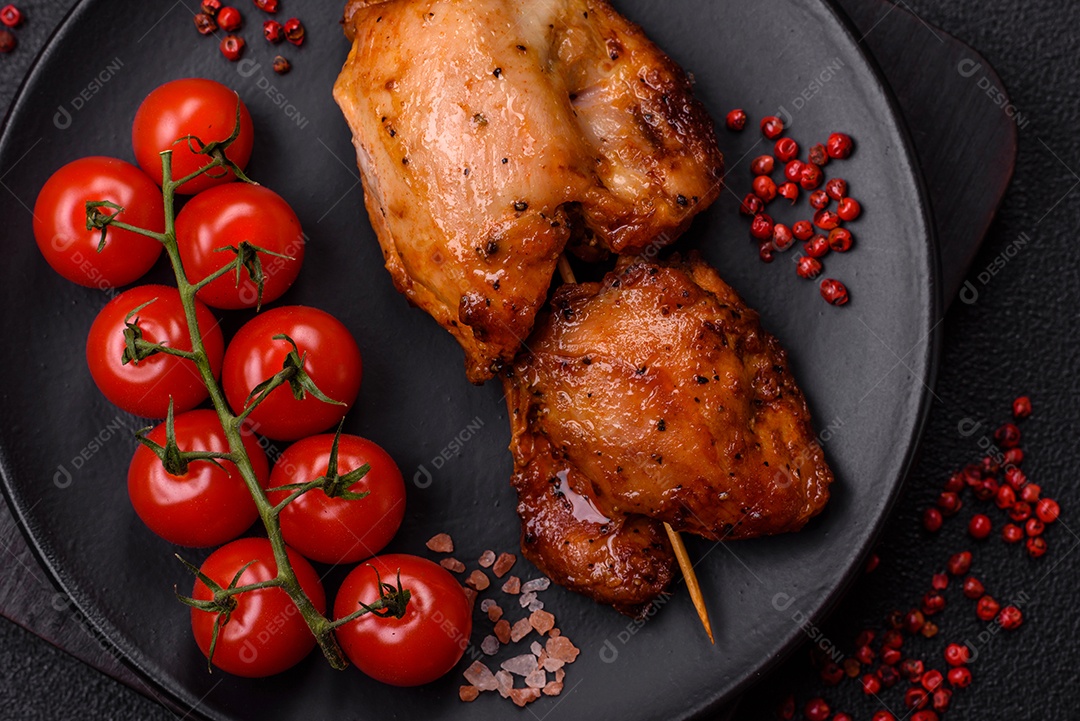 Kebab de frango suculento com sal, especiarias e ervas em um fundo escuro de concreto