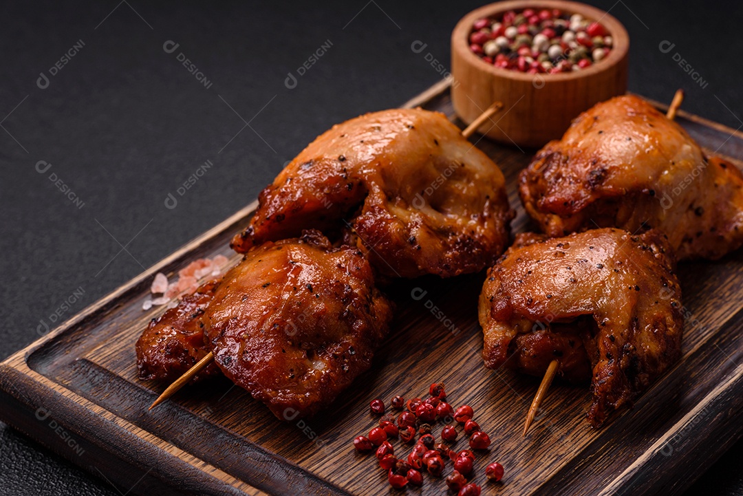 Kebab de frango suculento com sal, especiarias e ervas em um fundo escuro de concreto