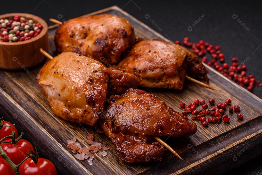 Kebab de frango suculento com sal, especiarias e ervas em um fundo escuro de concreto