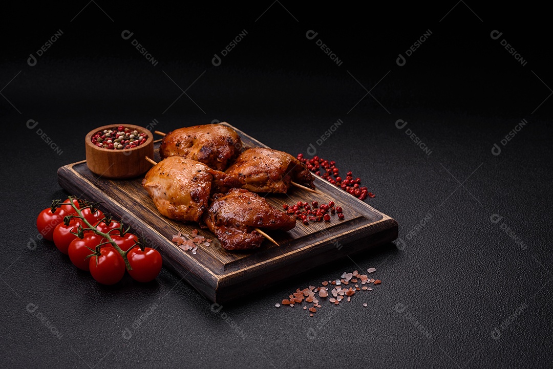 Kebab de frango suculento com sal, especiarias e ervas em um fundo escuro de concreto