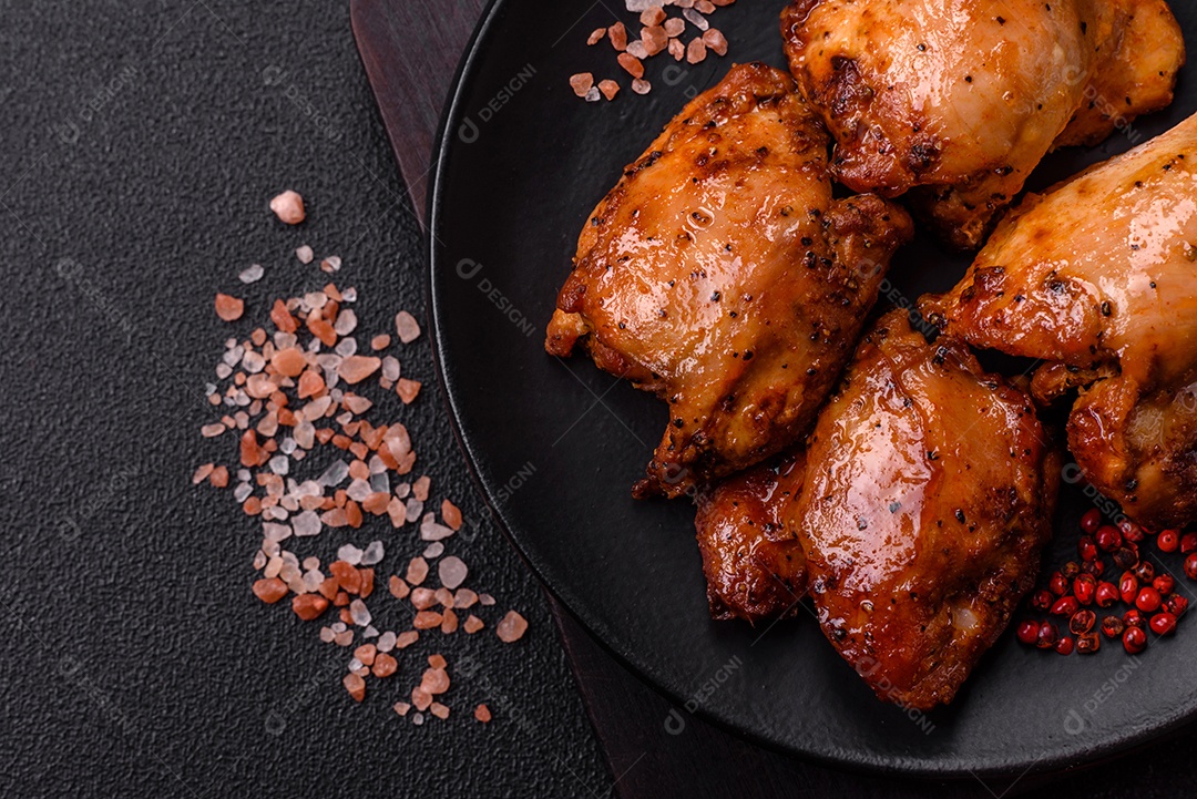 Kebab de frango suculento com sal, especiarias e ervas em um fundo escuro de concreto