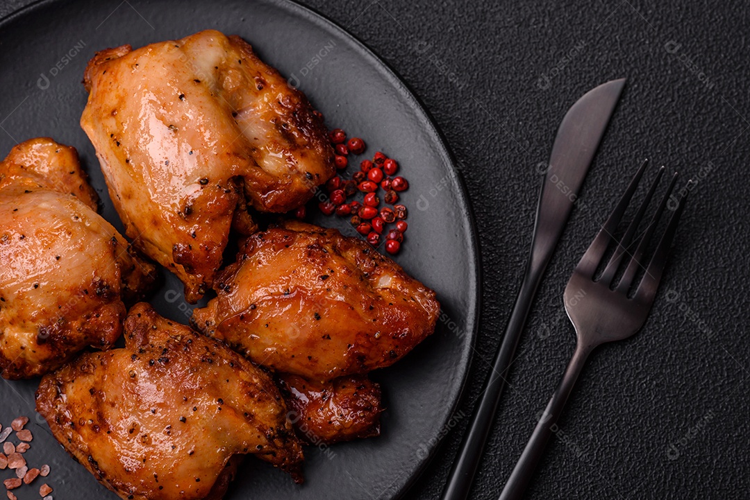 Kebab de frango suculento com sal, especiarias e ervas em um fundo escuro de concreto