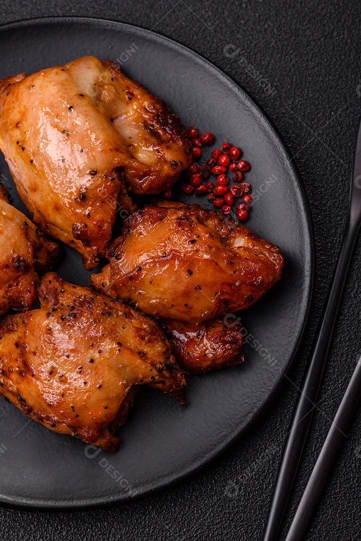 Kebab de frango suculento com sal, especiarias e ervas em um fundo escuro de concreto