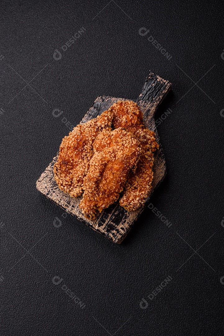 Deliciosos nuggets de frango crocantes frescos em um fundo escuro de concreto. Alimentos não saudáveis, fast food