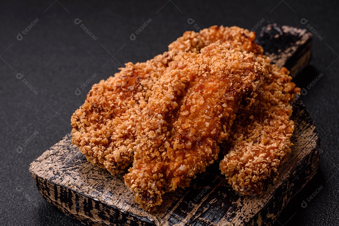 Deliciosos nuggets de frango crocantes frescos em um fundo escuro de concreto. Alimentos não saudáveis, fast food