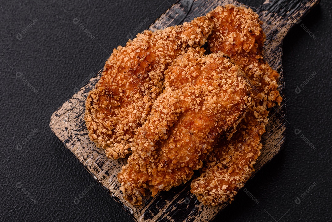 Deliciosos nuggets de frango crocantes frescos em um fundo escuro de concreto. Alimentos não saudáveis, fast food