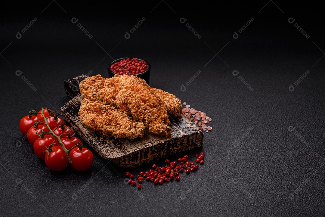 Deliciosos nuggets de frango crocantes frescos em um fundo escuro de concreto. Alimentos não saudáveis, fast food