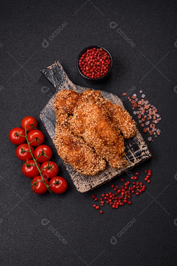 Deliciosos nuggets de frango crocantes frescos em um fundo escuro de concreto. Alimentos não saudáveis, fast food