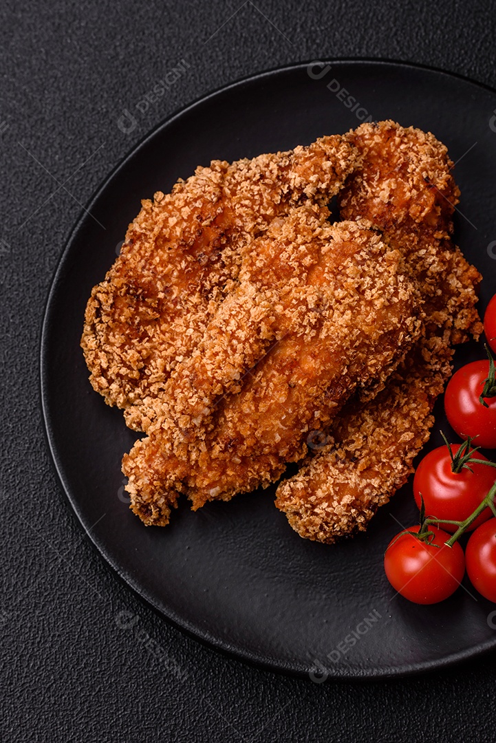 Deliciosos nuggets de frango crocantes frescos em um fundo escuro de concreto. Alimentos não saudáveis, fast food