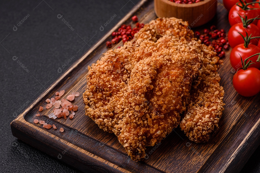 Deliciosos nuggets de frango crocantes frescos em um fundo escuro de concreto. Alimentos não saudáveis, fast food