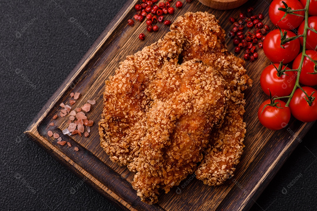Deliciosos nuggets de frango crocantes frescos em um fundo escuro de concreto. Alimentos não saudáveis, fast food