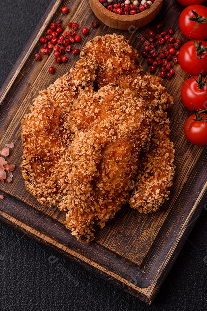 Deliciosos nuggets de frango crocantes frescos em um fundo escuro de concreto. Alimentos não saudáveis, fast food