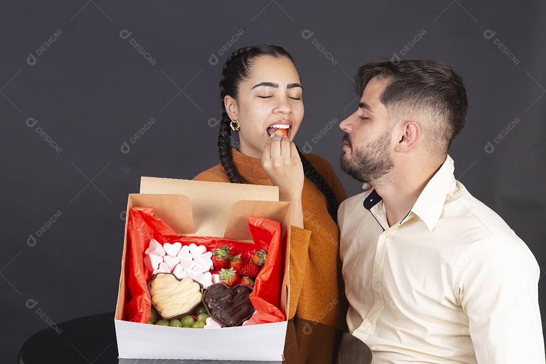 Lindo casal com cesta de doces para comemorar dia dos namorados