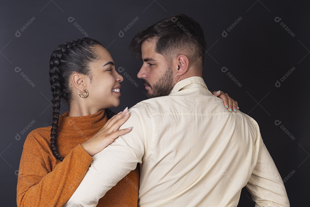 Casal jovem abraçados sobre fundo escuro