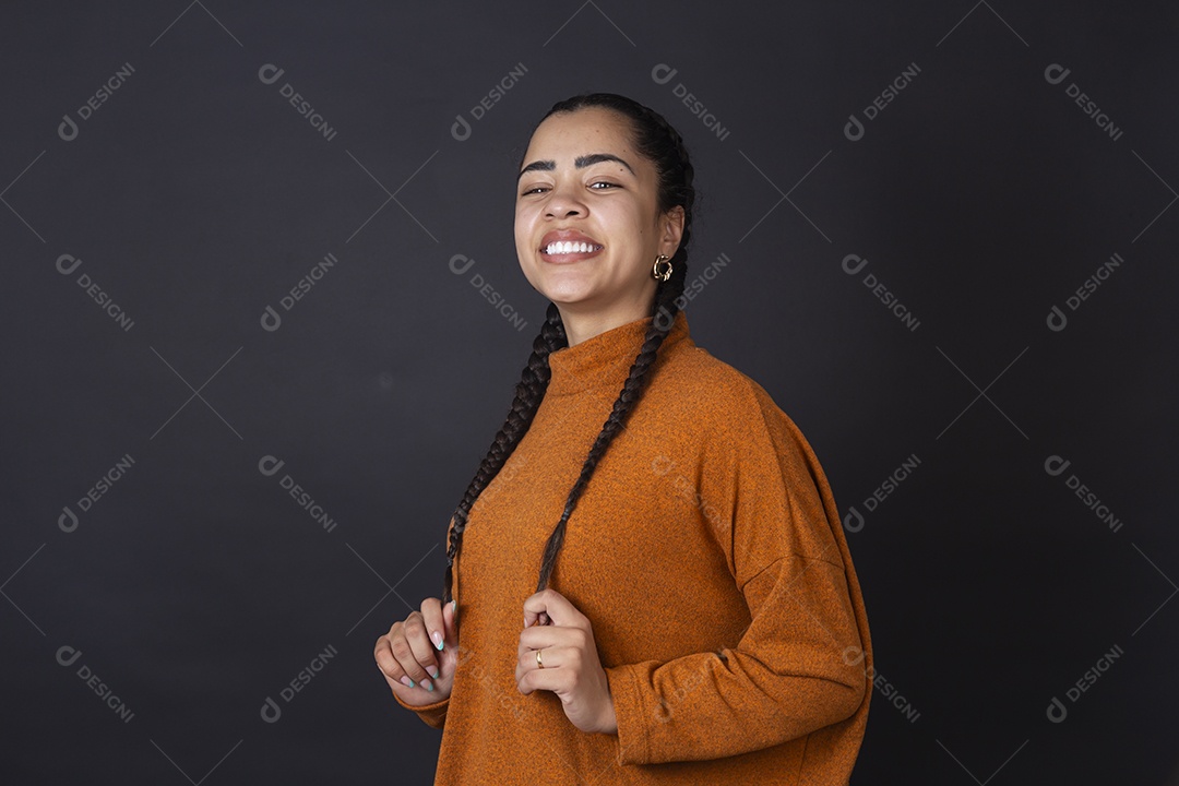 Mulher jovem sorrindo com pose sobre fundo escuro