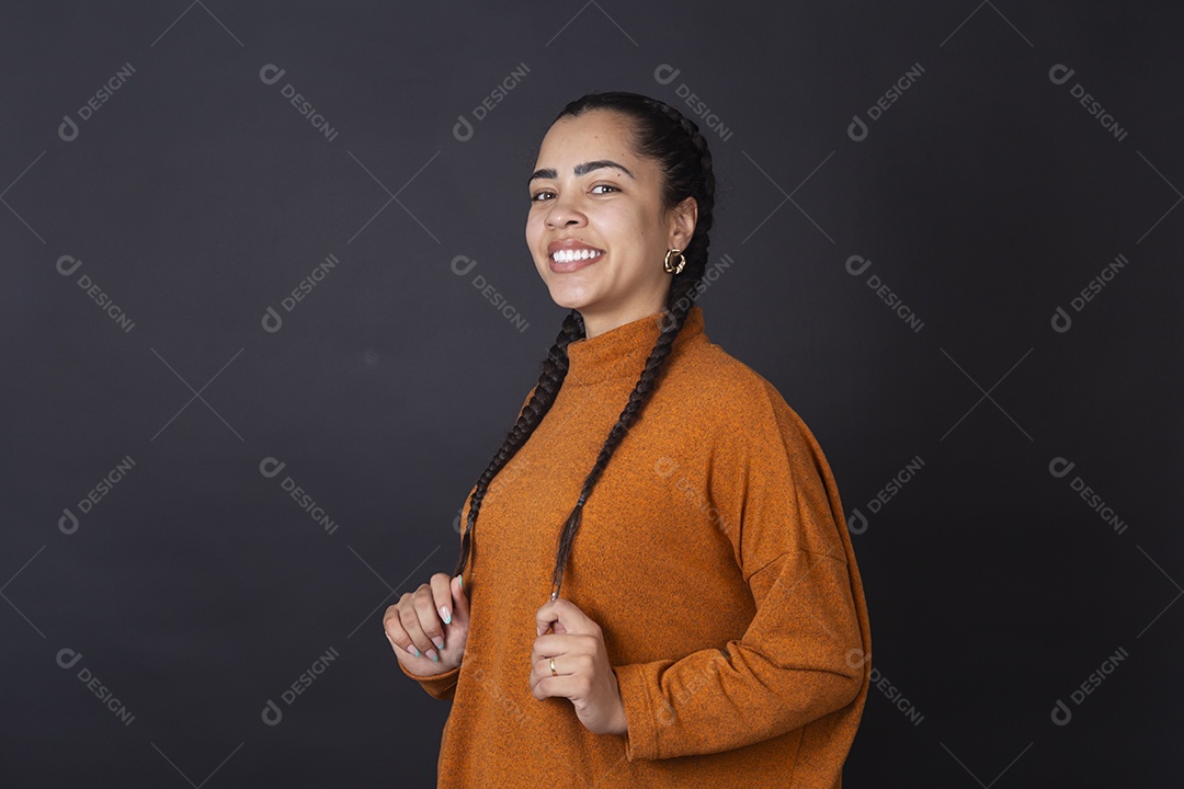 Mulher sorrindo fazendo pose sobre fundo escuro