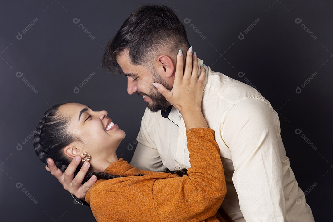 Casal se olhando e sorrindo sobre fundo escuro