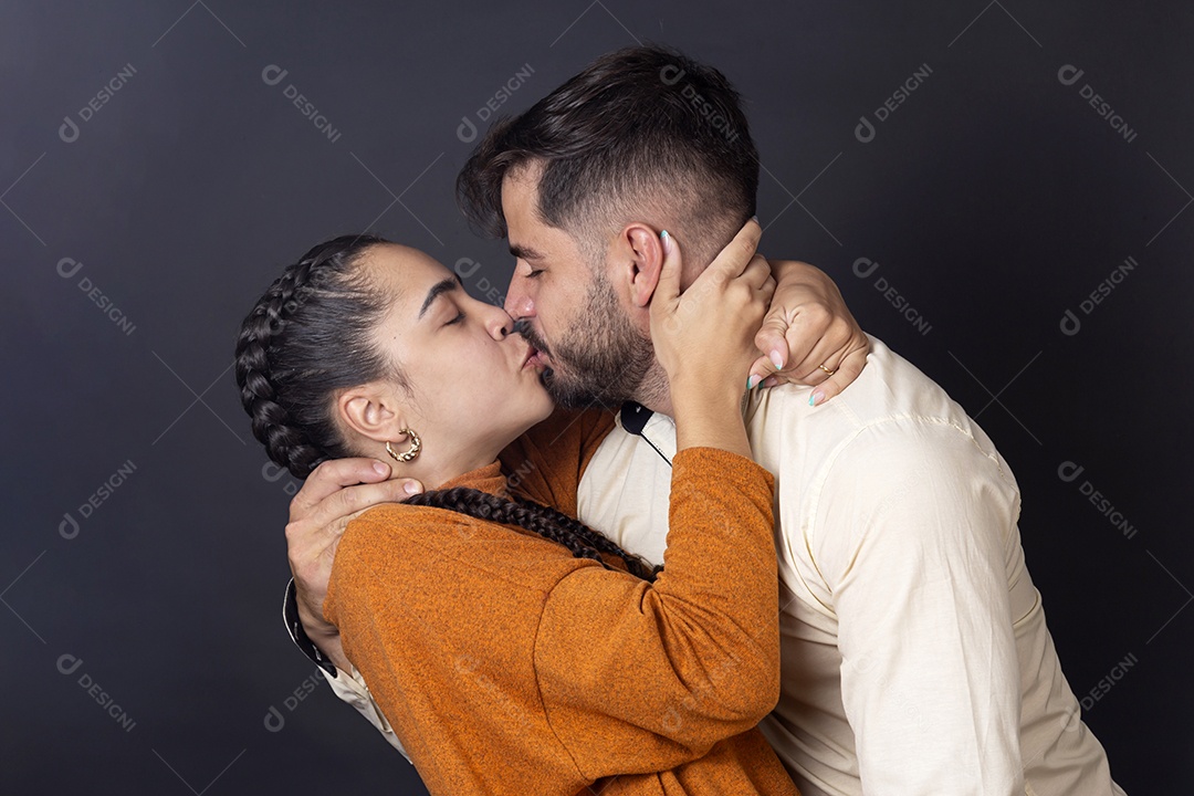 Casal se beijando para tirar foto sobre fundo escuro