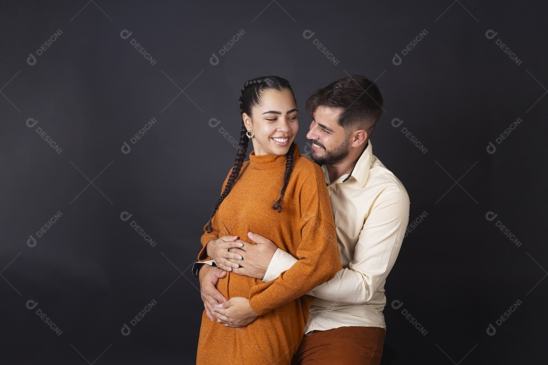 Casal se olhando e sorrindo sobre fundo escuro