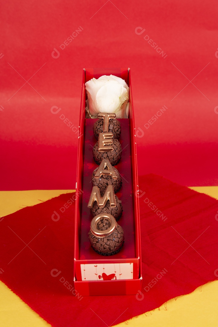 Caixa de brigadeiro com frase te amo para dia dos namorados sobre fundo vermelho