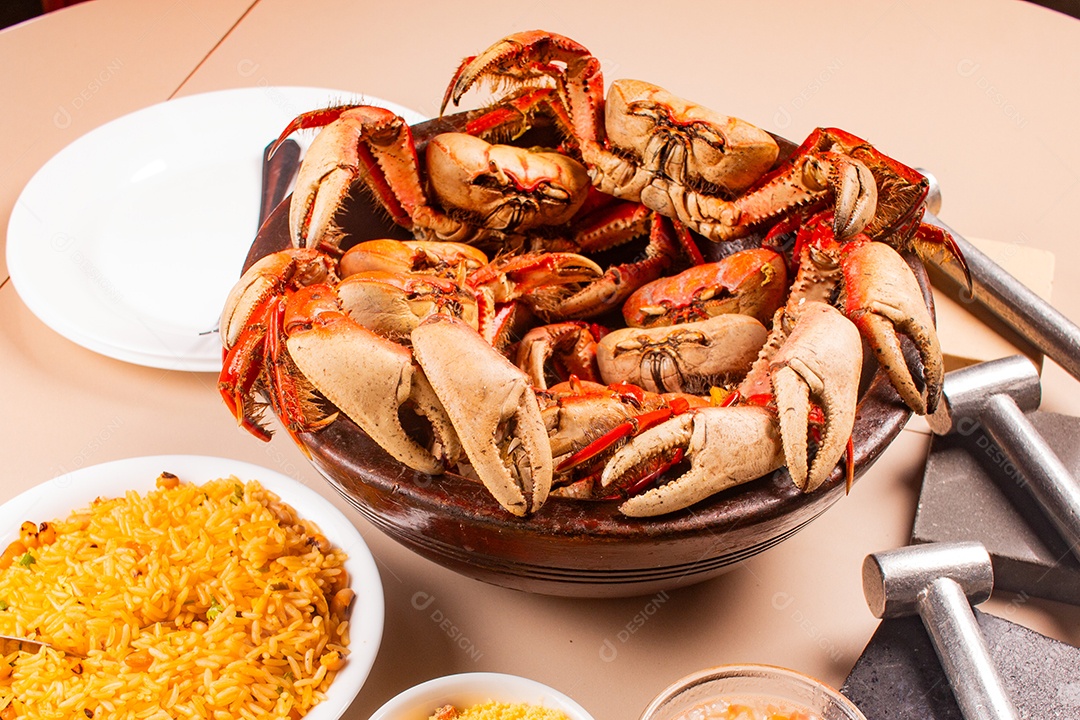 Caranguejo cozinho com acompanhamentos sobre uma mesa