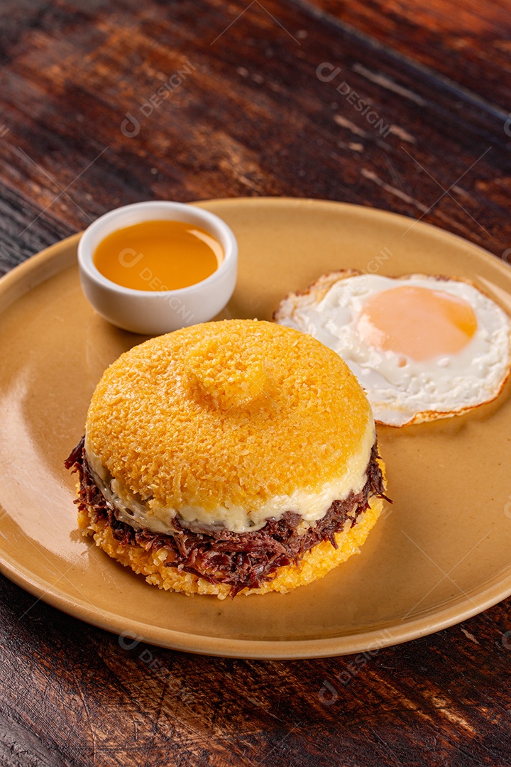 Cuscuz de milho recheado com carne de sol e ovos ao lado