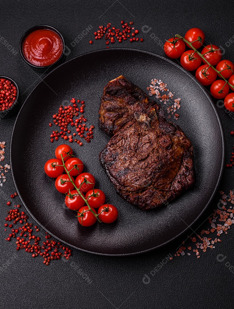 Delicioso bife suculento de lombo grelhado com sal, especiarias e ervas em um fundo escuro de concreto
