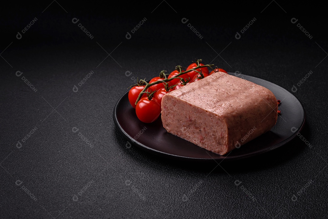 Delicioso presunto rosa enlatado com sal, especiarias e ervas sobre um fundo escuro de concreto