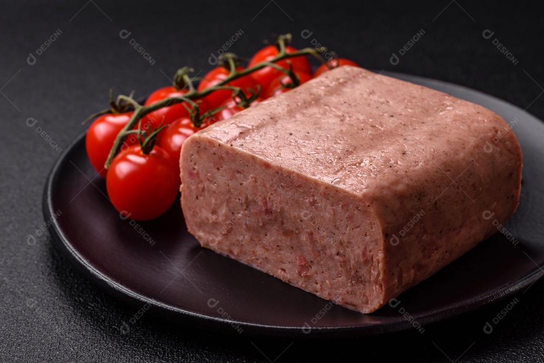 Delicioso presunto rosa enlatado com sal, especiarias e ervas sobre um fundo escuro de concreto