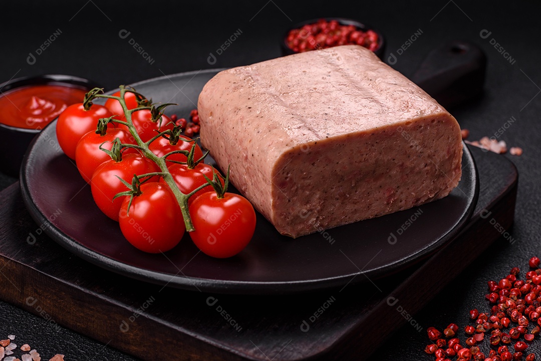 Delicioso presunto rosa enlatado com sal, especiarias e ervas sobre um fundo escuro de concreto