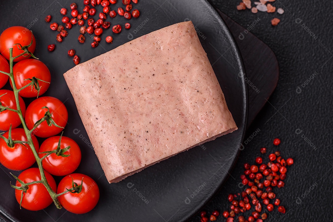 Delicioso presunto rosa enlatado com sal, especiarias e ervas sobre um fundo escuro de concreto