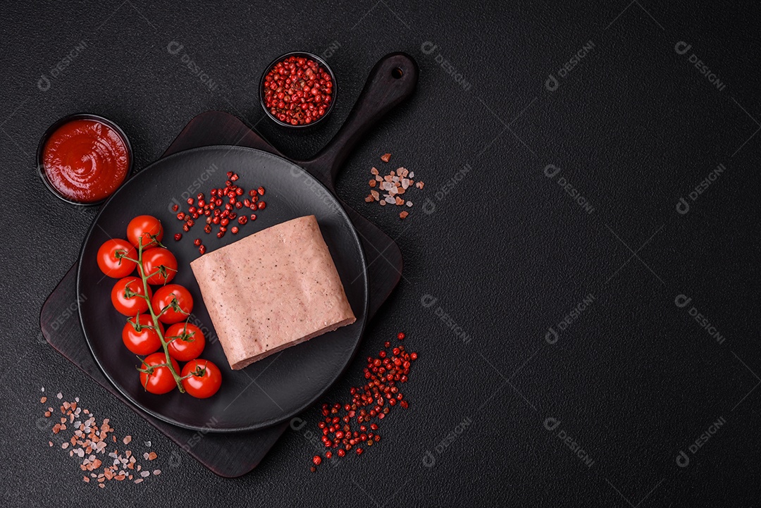 Delicioso presunto rosa enlatado com sal, especiarias e ervas sobre um fundo escuro de concreto