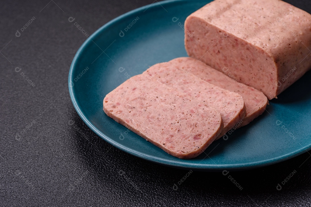 Delicioso presunto rosa enlatado com sal, especiarias e ervas sobre um fundo escuro de concreto