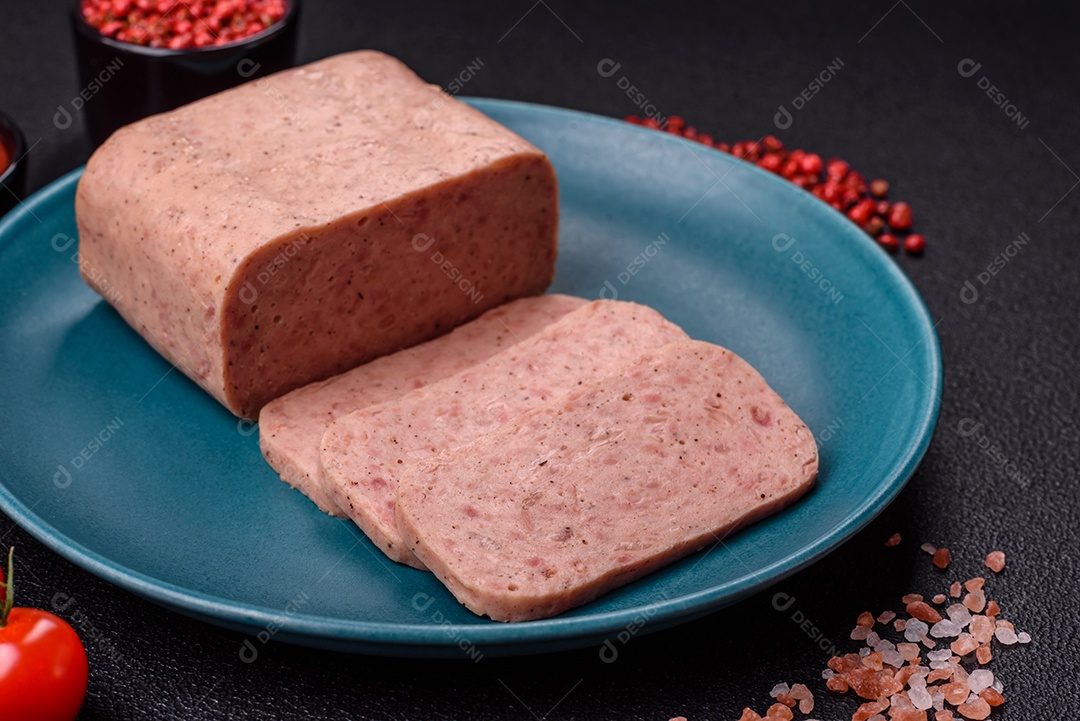 Delicioso presunto rosa enlatado com sal, especiarias e ervas sobre um fundo escuro de concreto