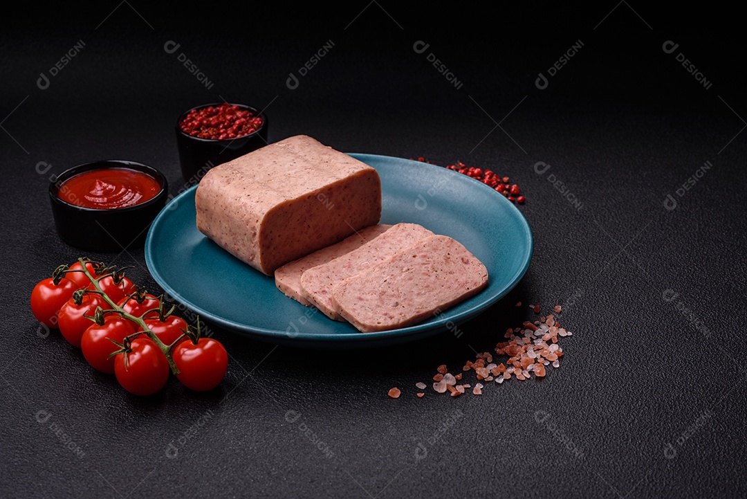 Delicioso presunto rosa enlatado com sal, especiarias e ervas sobre um fundo escuro de concreto