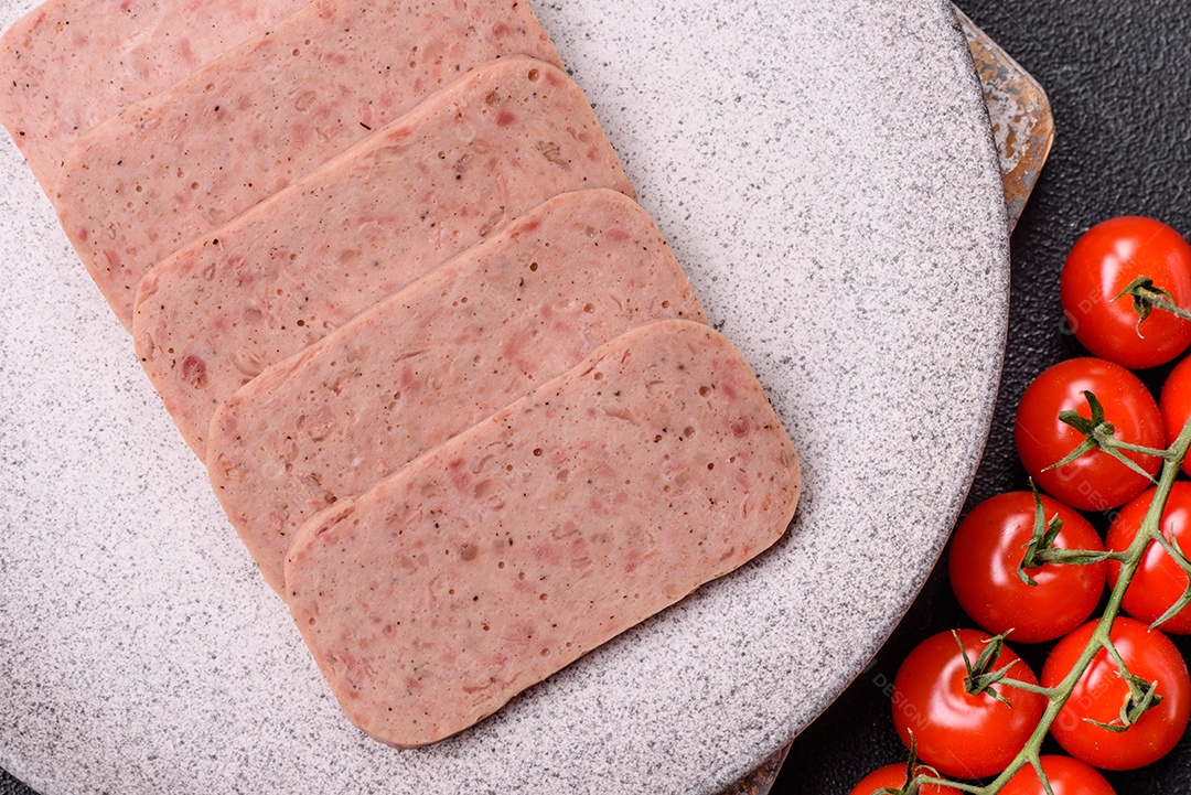 Delicioso presunto rosa enlatado com sal, especiarias e ervas sobre um fundo escuro de concreto