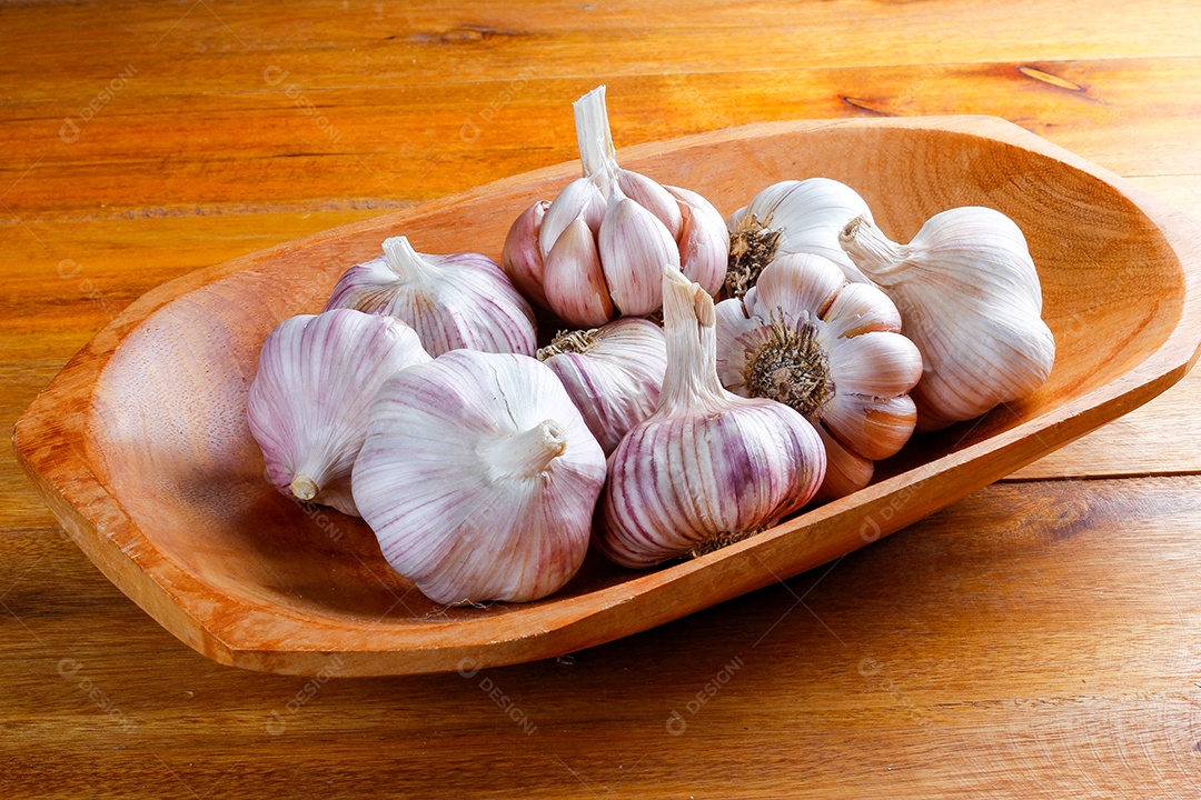 Dentes de alho em bandeja de madeira