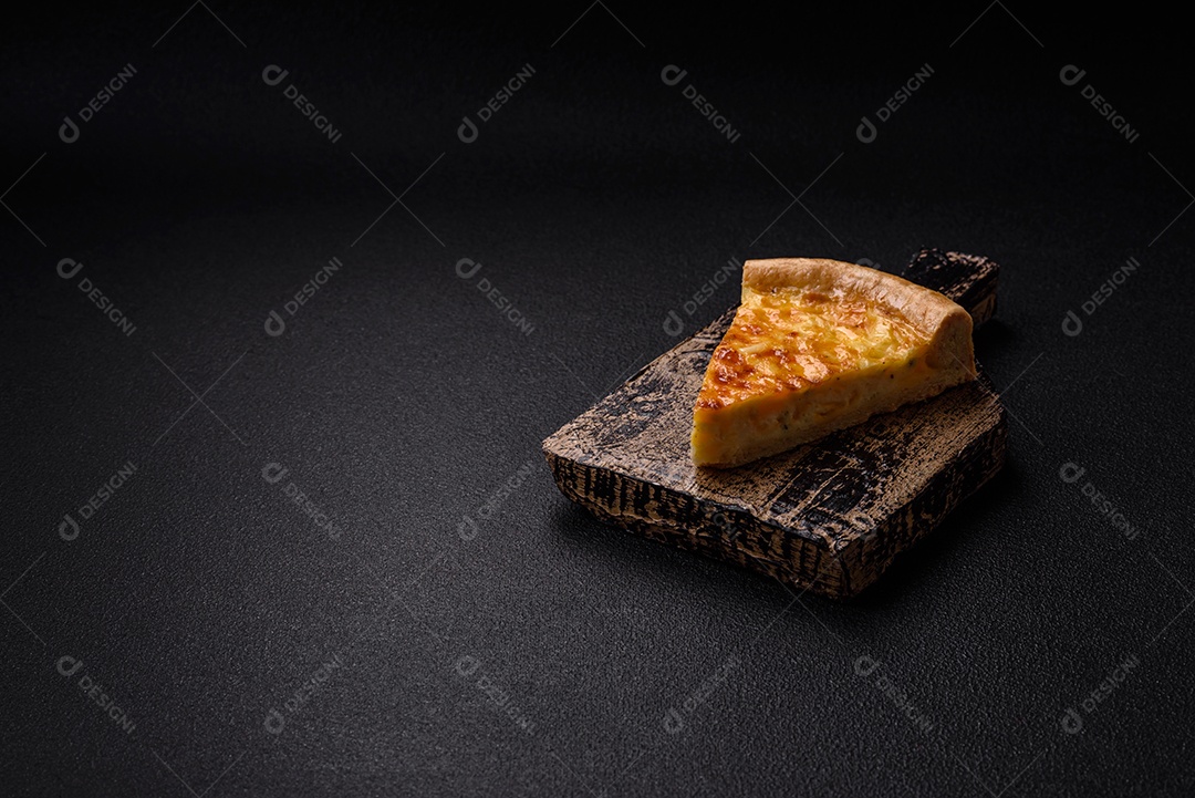 Deliciosa quiche com brócolis, frango ou salmão e queijo com sal e especiarias sobre fundo escuro de concreto