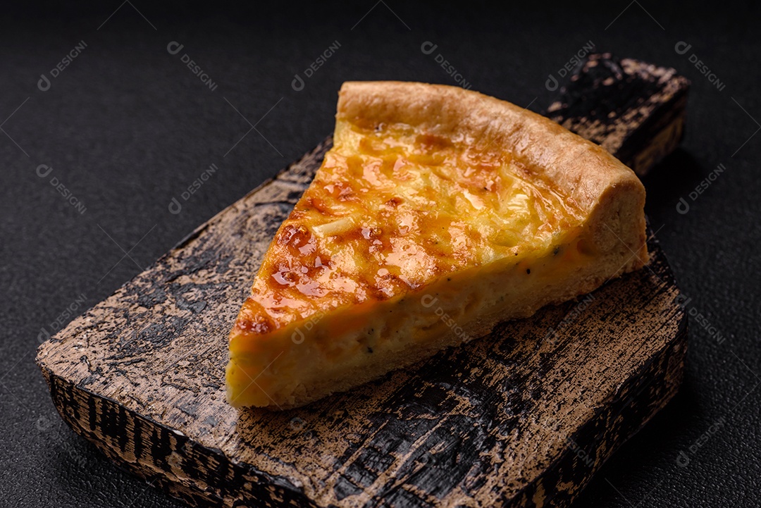 Deliciosa quiche com brócolis, frango ou salmão e queijo com sal e especiarias sobre fundo escuro de concreto