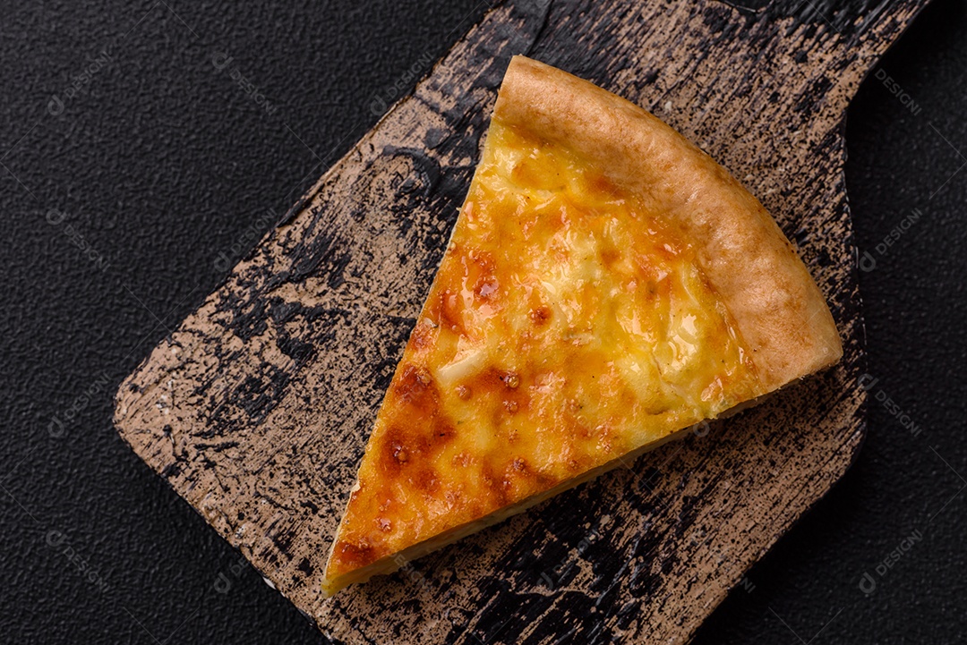 Deliciosa quiche com brócolis, frango ou salmão e queijo com sal e especiarias sobre fundo escuro de concreto