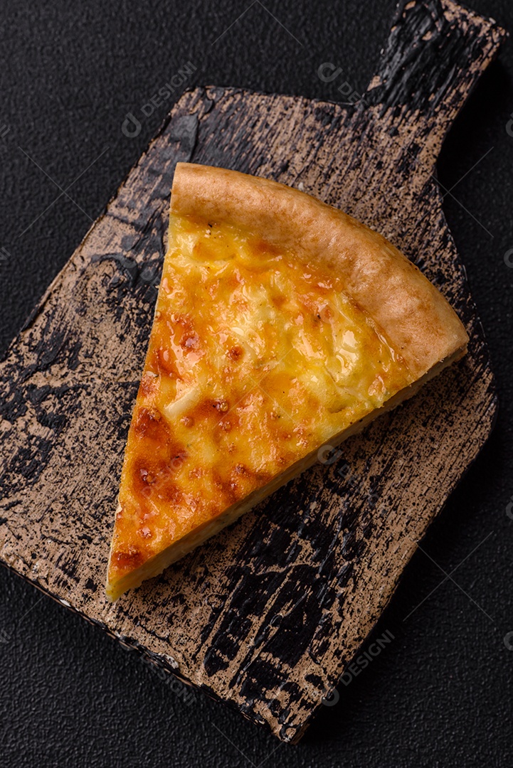 Deliciosa quiche com brócolis, frango ou salmão e queijo com sal e especiarias sobre fundo escuro de concreto