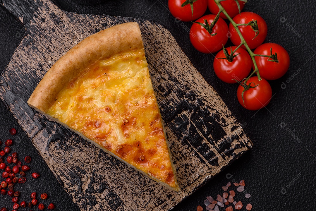 Deliciosa quiche com brócolis, frango ou salmão e queijo com sal e especiarias sobre fundo escuro de concreto
