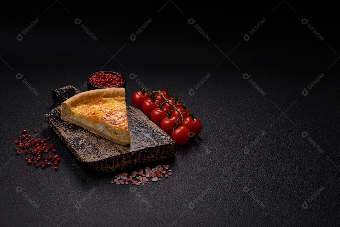 Deliciosa quiche com brócolis, frango ou salmão e queijo com sal e especiarias sobre fundo escuro de concreto