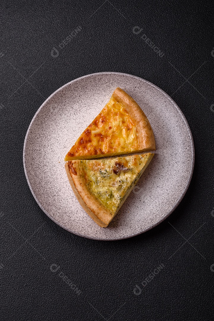Deliciosa quiche com brócolis, frango ou salmão e queijo com sal e especiarias sobre fundo escuro de concreto