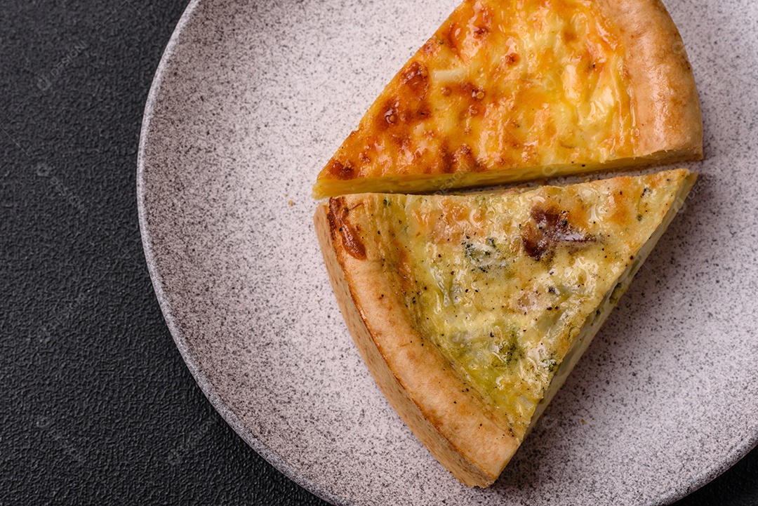Deliciosa quiche com brócolis, frango ou salmão e queijo com sal e especiarias sobre fundo escuro de concreto