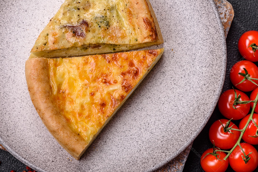 Deliciosa quiche com brócolis, frango ou salmão e queijo com sal e especiarias sobre fundo escuro de concreto